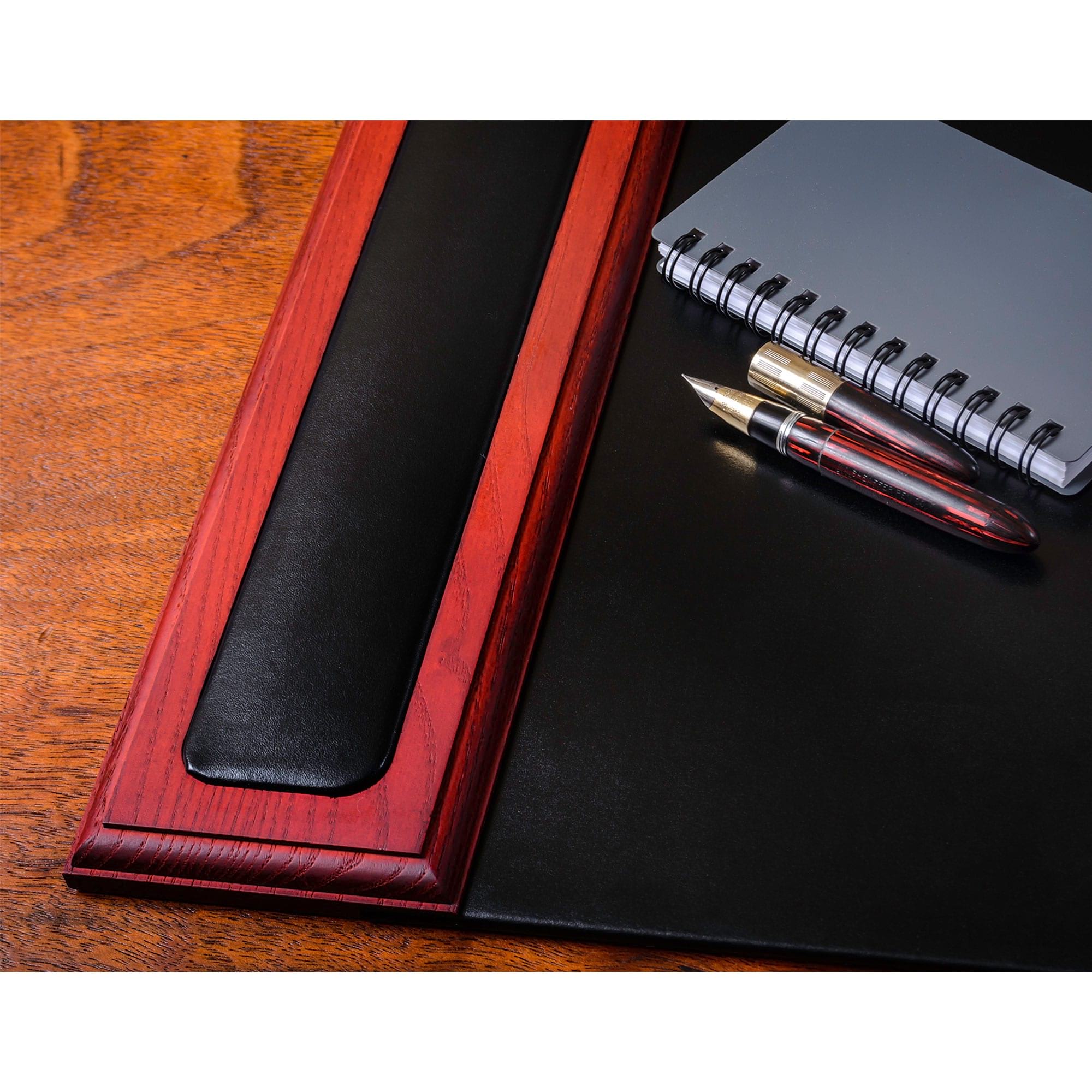 Black leather desk pad with red wooden frame on a wooden surface