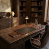 Wooden desk with leather chair in a room with bookshelves and world map